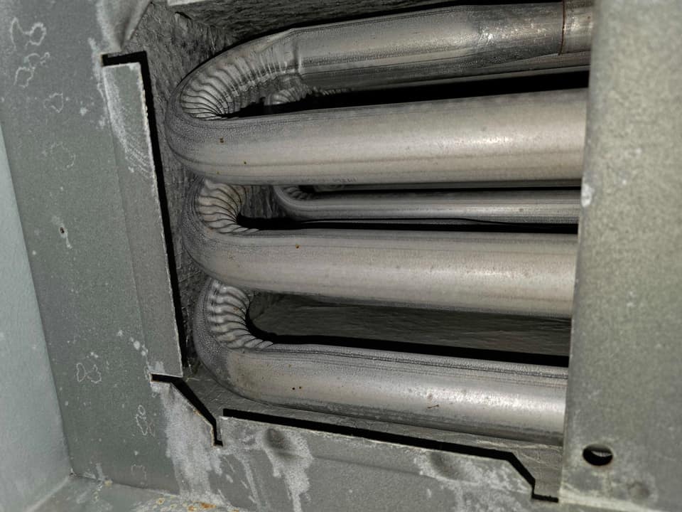 Technician inspecting a furnace heat exchanger during a heating repair